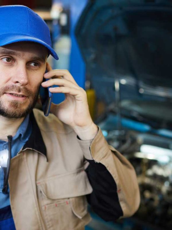 An auto mechanic on the phone with customer